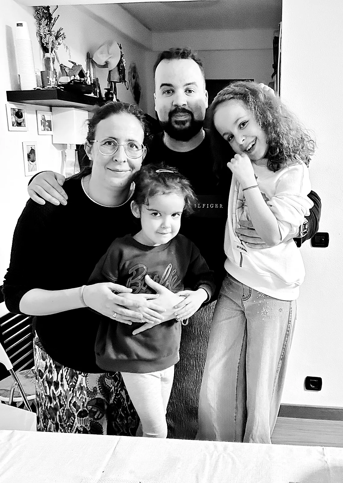 O Marcos em casa com a mulher e as duas filhas, a preto e branco