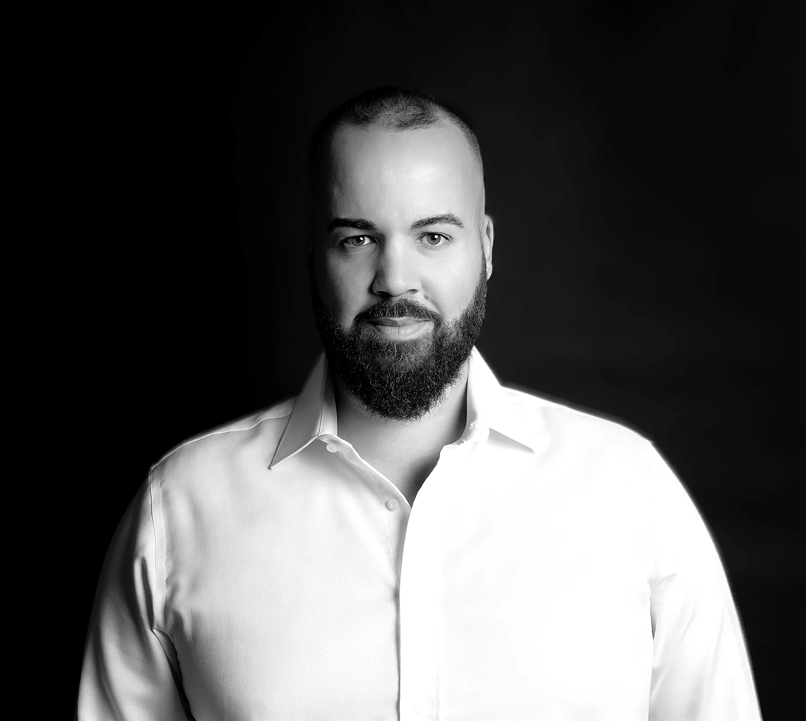 Retrato de estúdio a preto e branco do Marcos Gonçalves, de camisa branca